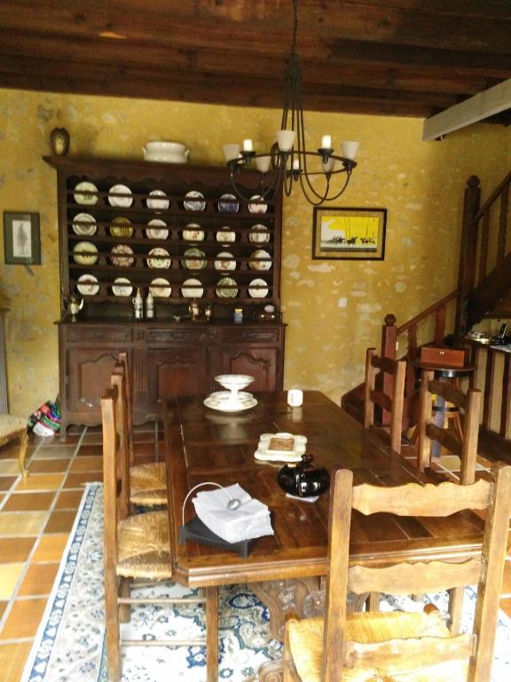 a dining room with a wooden table and chairs at Chambre d&#39;hôtes Le Moulin de Moulis in Moulis-en-Médoc