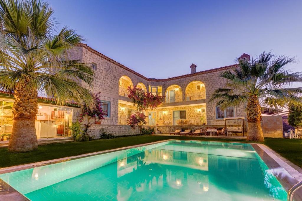 una casa con piscina y palmeras en Villa Fora Hotel, en Alacati