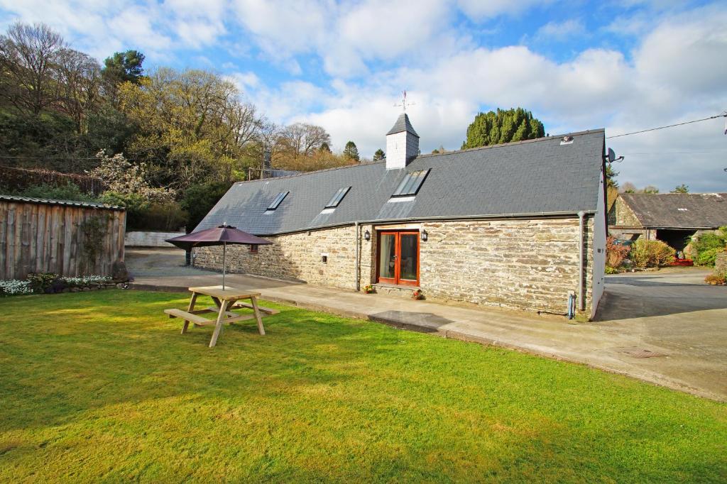 a small brick building with a picnic table in the grass at Degwm in Llanwrin