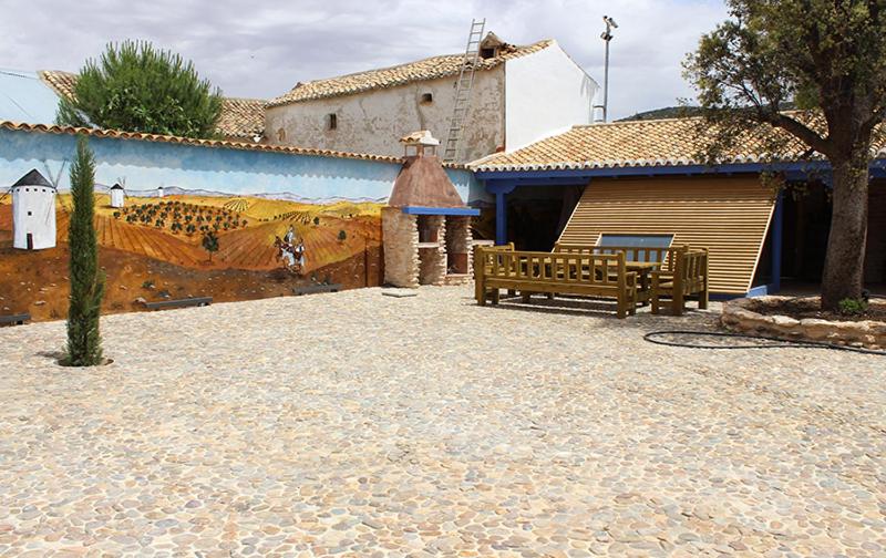 a bench sitting in a courtyard next to a building at Casa Rural La Tia Lola in Puerto Lápice