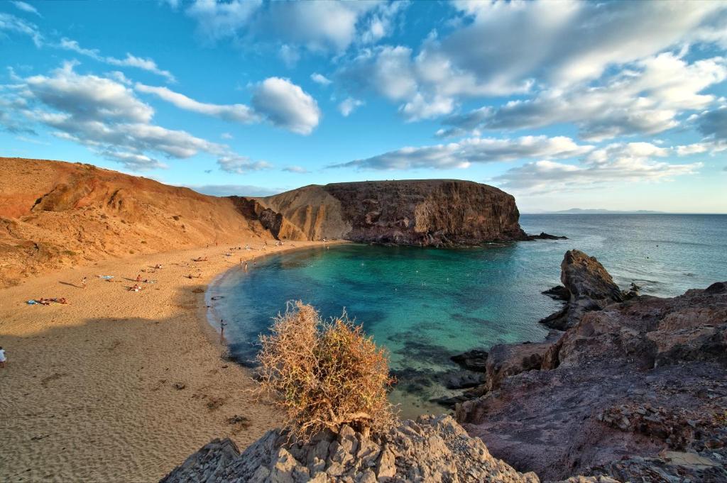 una spiaggia con una grande roccia in acqua di Apartmento Juana 2 a Puerto del Carmen