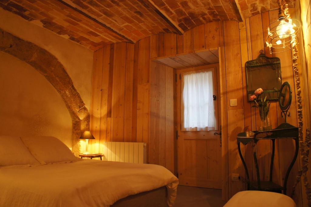 1 dormitorio con 1 cama en una habitación con paredes de madera en la chambre d'hôte, en Lourmarin