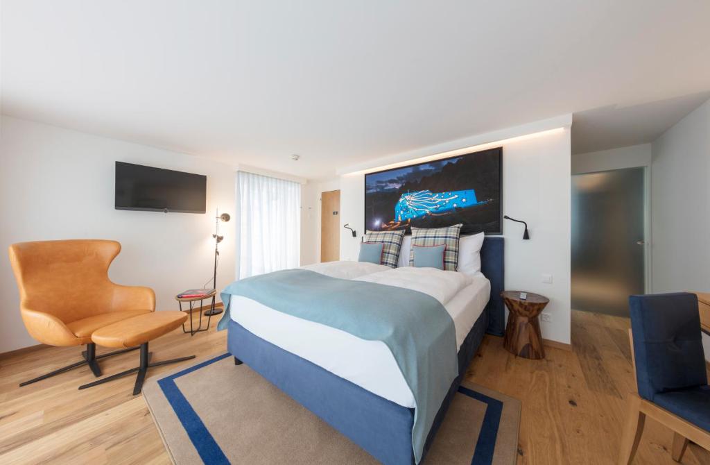 a hotel room with a bed and a chair at Fred Hotel Leonhardstrasse - Self Check-in in Zürich