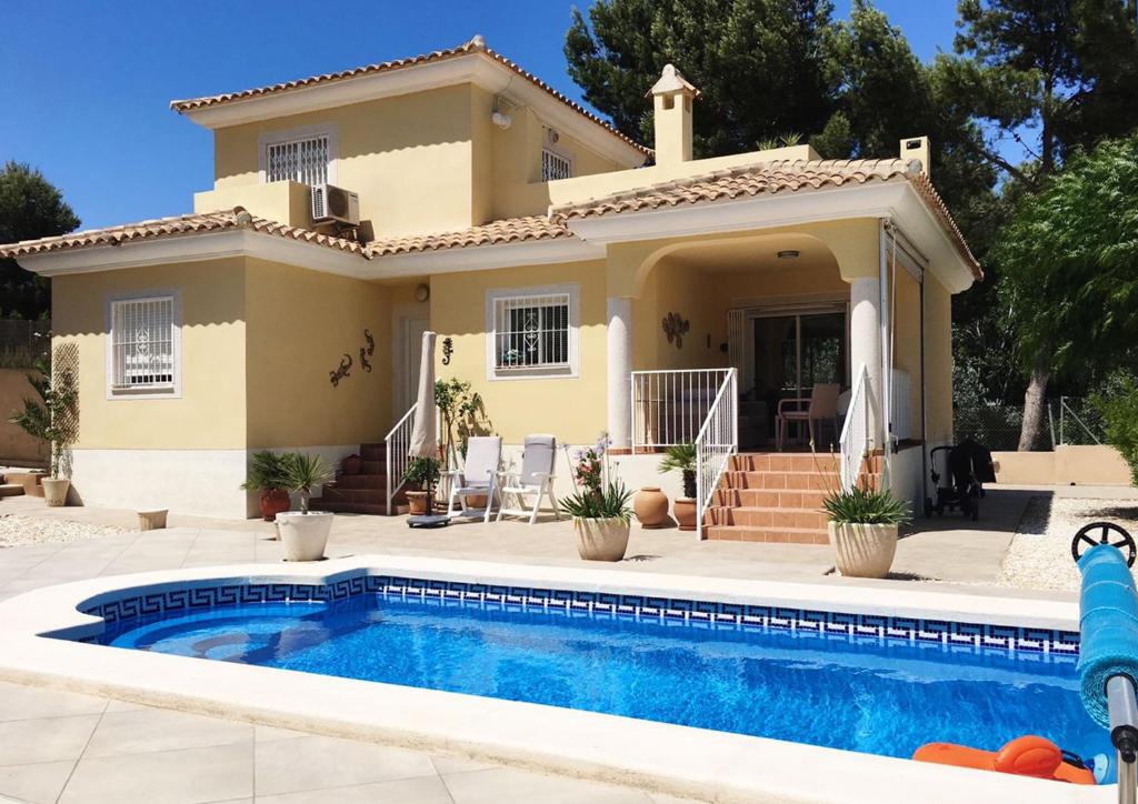 a villa with a swimming pool in front of a house at Pinada del Rio Villa, Alicante in Tibi