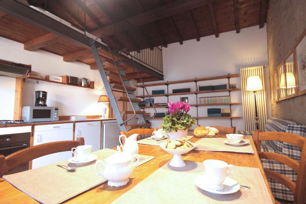 eine Küche und ein Esszimmer mit einem Tisch und Stühlen in der Unterkunft Esenta 55 - Lago di Garda in Esenta