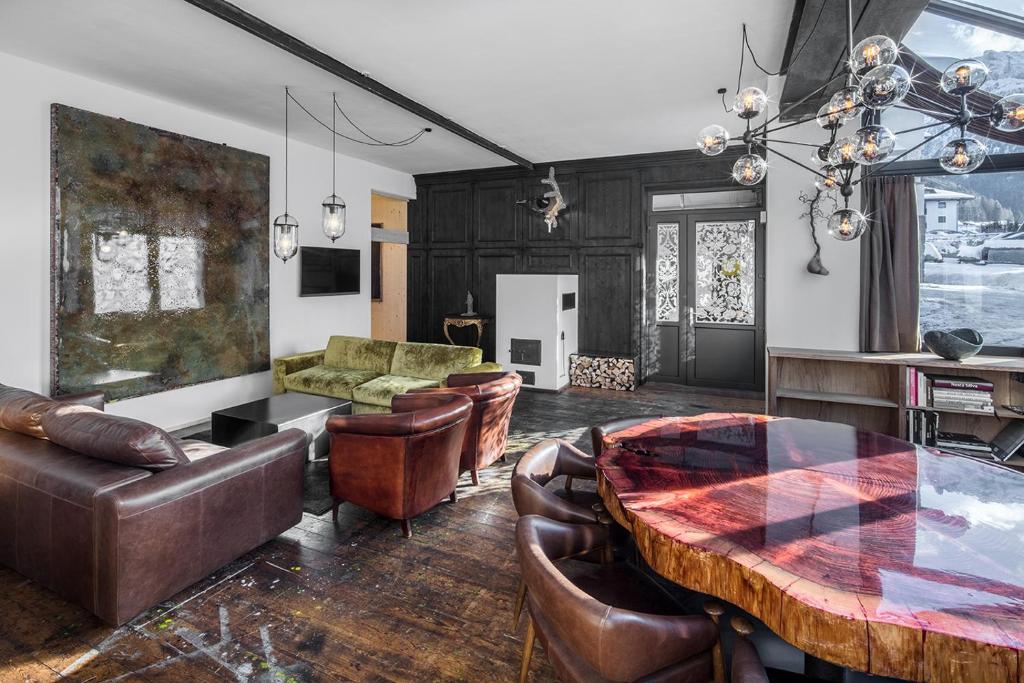 a living room with a table and leather chairs at Artefugium Atelier - Apartments in Selva di Val Gardena