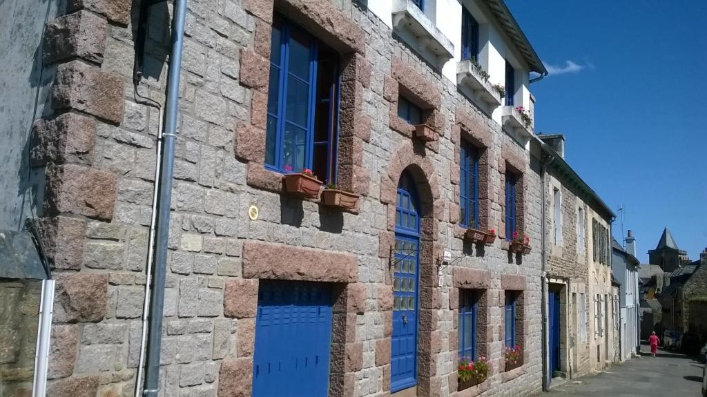 a building with blue doors and windows on a street at Chambres de Scavet in Tréguier