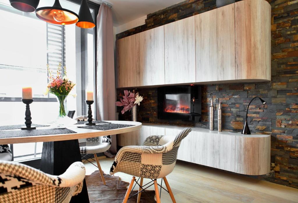 kuchnia ze stołem, krzesłami i kominkiem w obiekcie Brunetti Design Apartment w Pradze