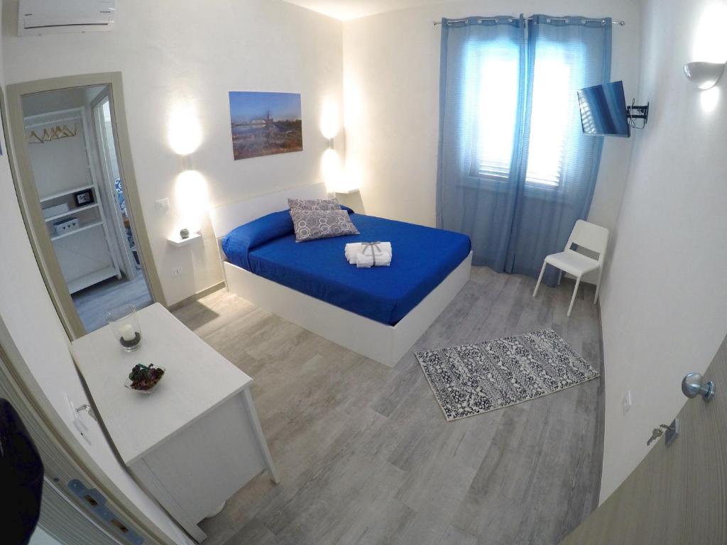 a small bedroom with a blue bed and a mirror at Sirio in Birgi Vecchi