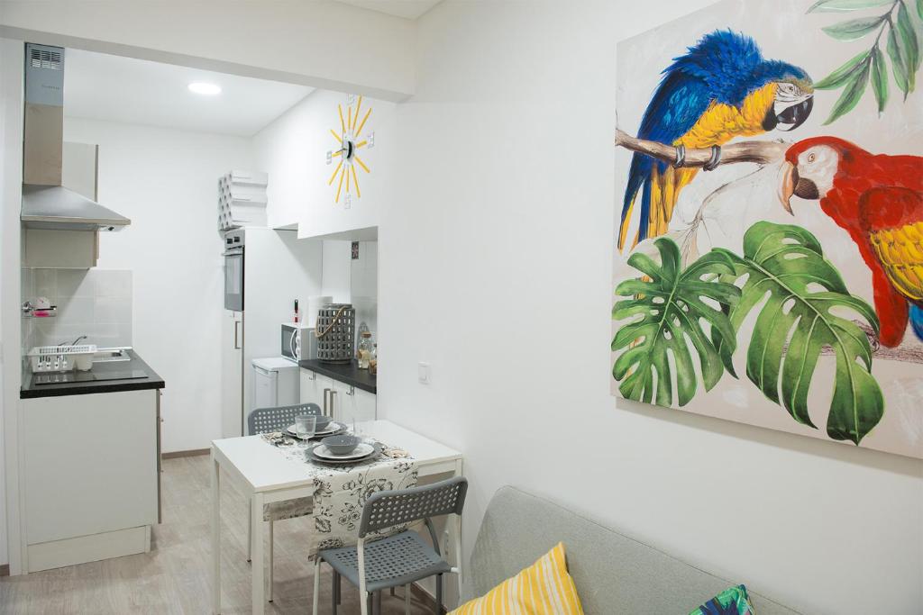 a living room with a bird painting on the wall at Tropical house in Sesimbra