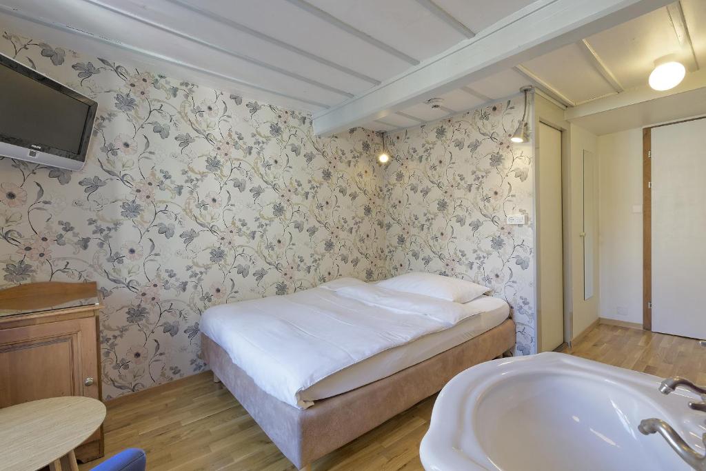 a bedroom with a bed and a tub and a sink at Alplodge in Interlaken