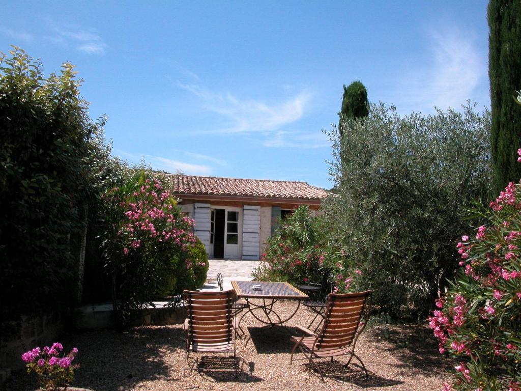 d'une terrasse avec 2 chaises et une table dans la cour. dans l'établissement Le Mazet de la Dame, à Barbentane