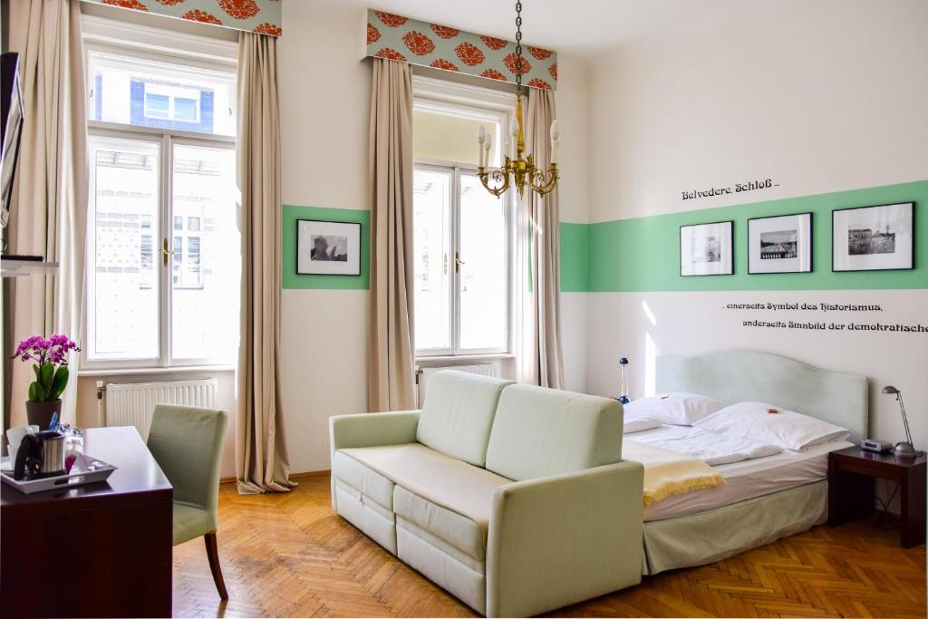 ein Schlafzimmer mit einem Bett, einem Sofa und einem Stuhl in der Unterkunft Pension Riedl in Wien