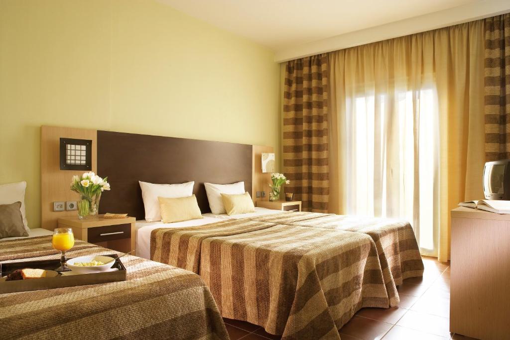 a hotel room with two beds and a television at Anessis in Thessaloniki