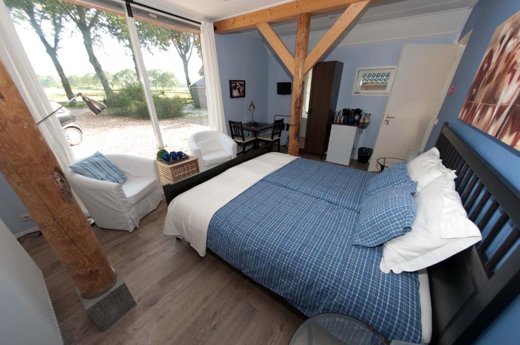 a bedroom with a blue and white bed and a window at De Violier in Eext