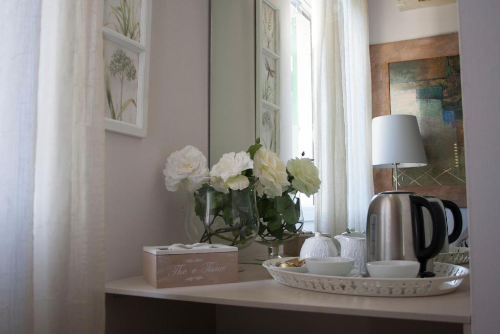 una mesa con un jarrón de flores blancas y una lámpara en B&B Villa Brema, en Sirmione