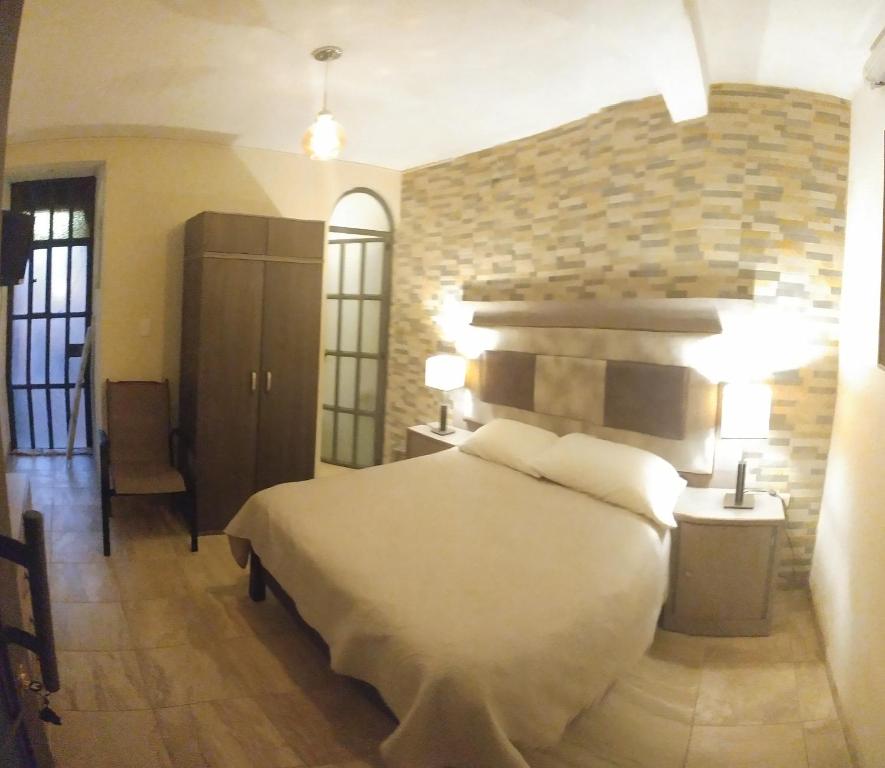Postel nebo postele na pokoji v ubytování Hotel Las Alamedas Guanajuato