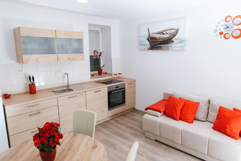 Hrvatini的住宿－Apartma Nika，厨房以及带沙发和桌子的客厅。