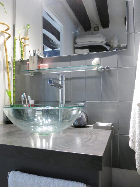 a bathroom with a glass bowl sink on a counter at Studio Marais Charlot CityCosy in Paris