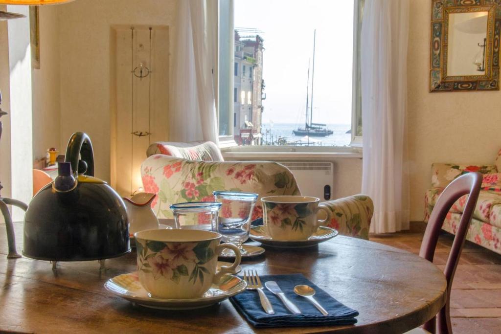 un tavolo con due tazze e un bollitore per il tè sopra di ALTIDO Apt on the Coast of Portofino with Lovely View a Portofino