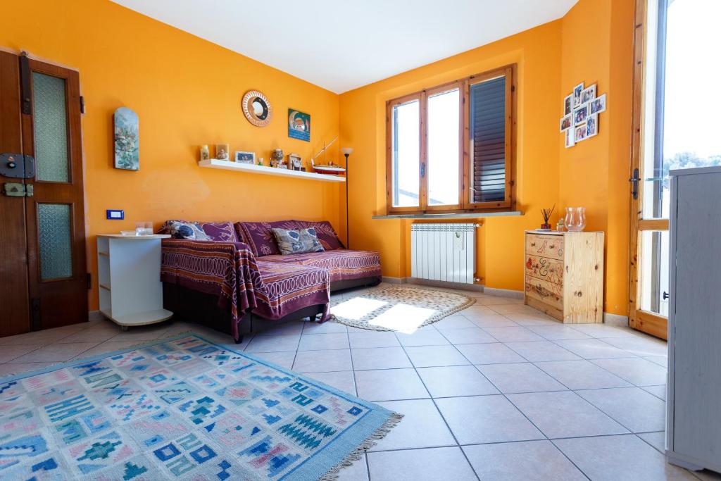 sala de estar con paredes de color naranja y sofá en Casa Guia, en Marina di Cecina