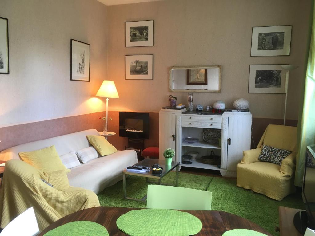 een woonkamer met een witte bank en stoelen bij La Chevalerie in Bléré
