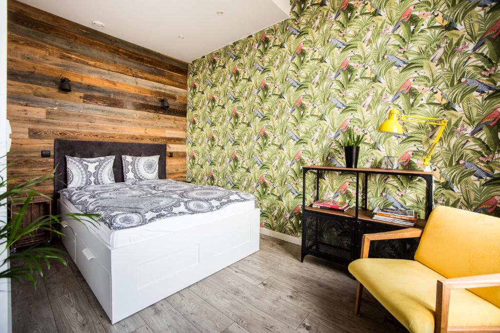 - une chambre avec un lit et un mur en bois dans l'établissement Boho Apartment, à Toruń