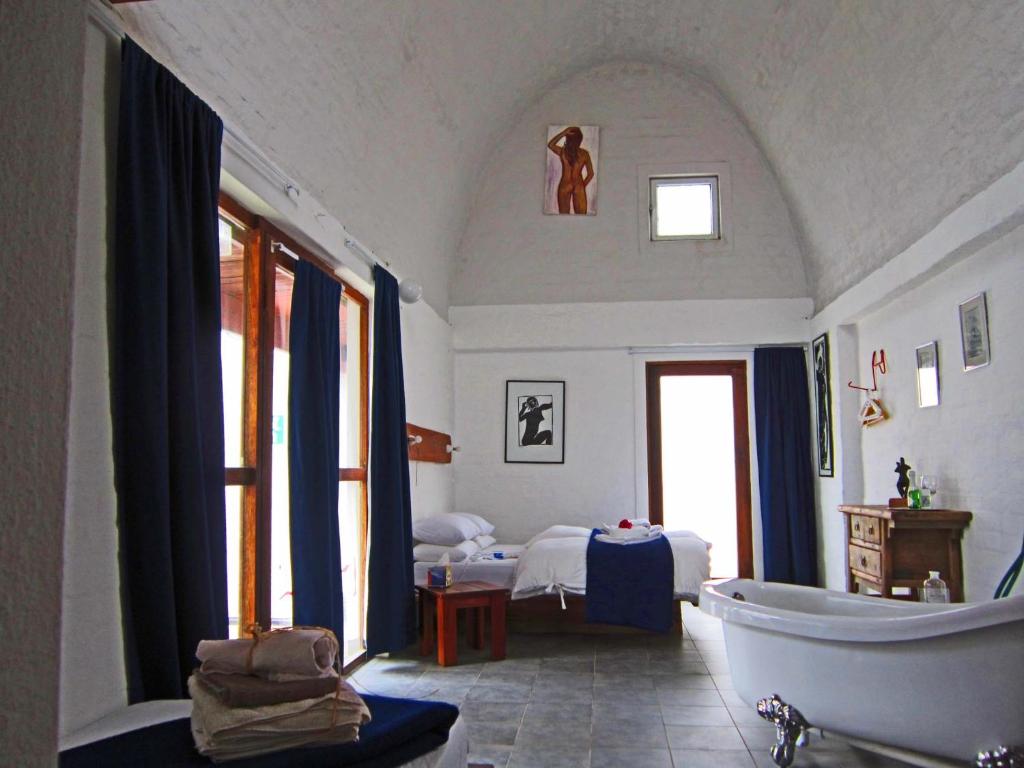 a bathroom with a bath tub and a bedroom at Alternative Space B & B in Swakopmund