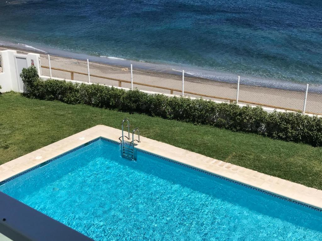 una piscina junto a una playa y el océano en Apartamento Nautilus Beach, en Carboneras