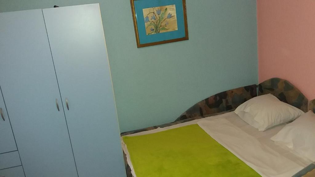 a small bedroom with a bed and a cabinet at Sobe Majda in Visoko