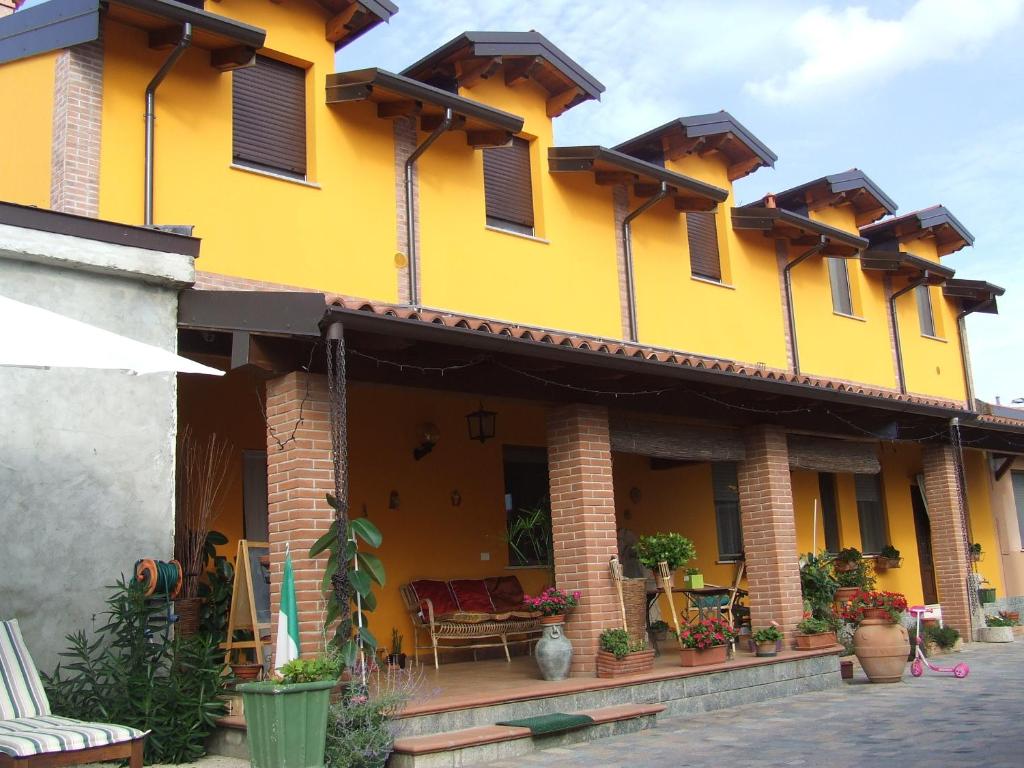 a yellow building with chairs and tables in a courtyard at B&B La Corte in Casorate Primo