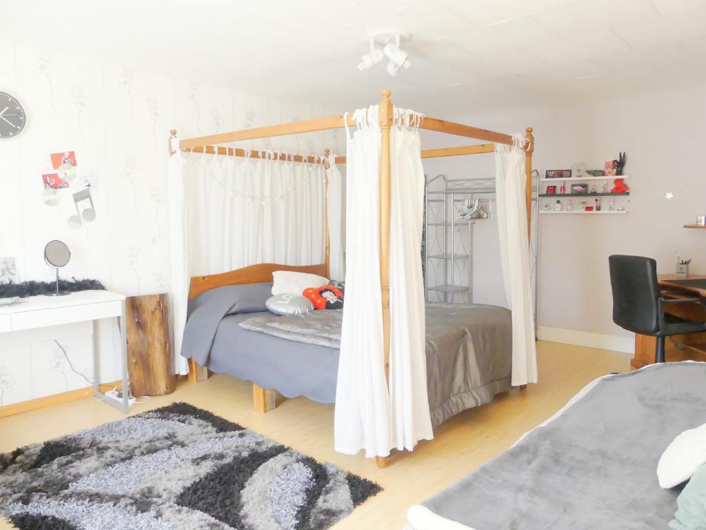 ein Schlafzimmer mit einem Himmelbett in der Unterkunft Studio Manon in Portieux