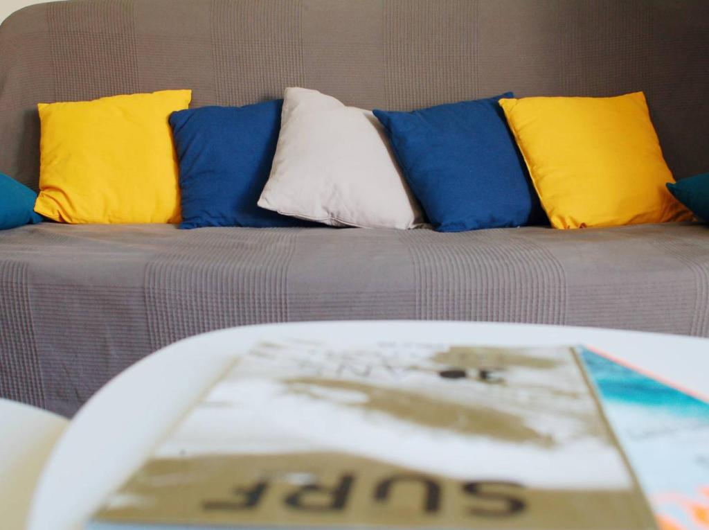 フェレルにあるAtlantic Surf Apartmentのカラフルな枕とテーブル付きのソファが備わるリビングルームです。
