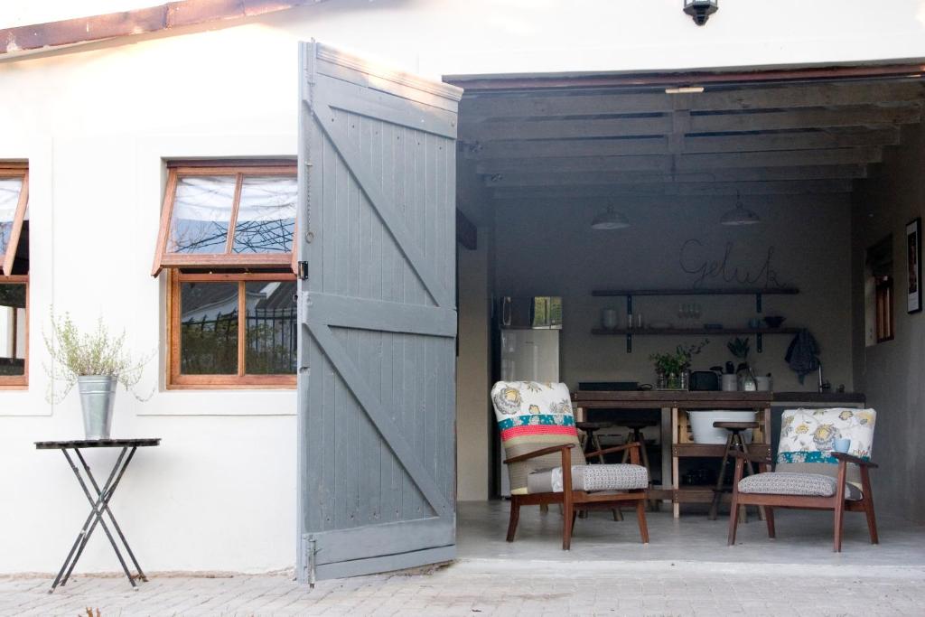 an open door to a patio with chairs and a table at Avo&Oak Guesthouse in George