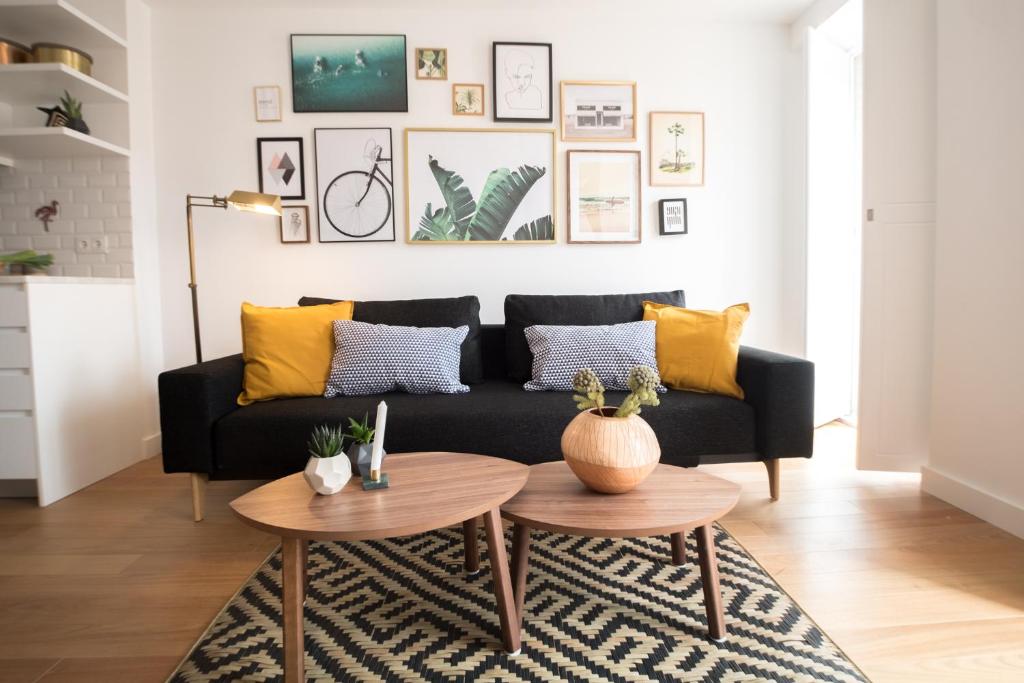 リスボンにあるVale Quiet & Comfort Flatのリビングルーム(黒いソファ、黄色い枕付)