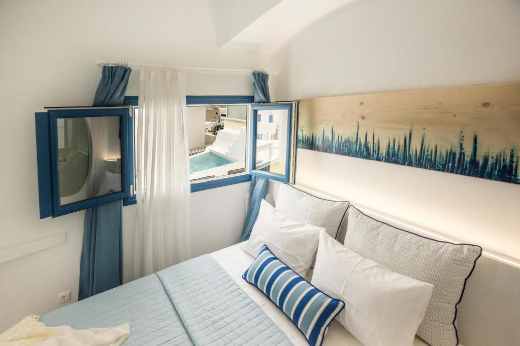a bedroom with a bed and a window at Amera Suites in Fira