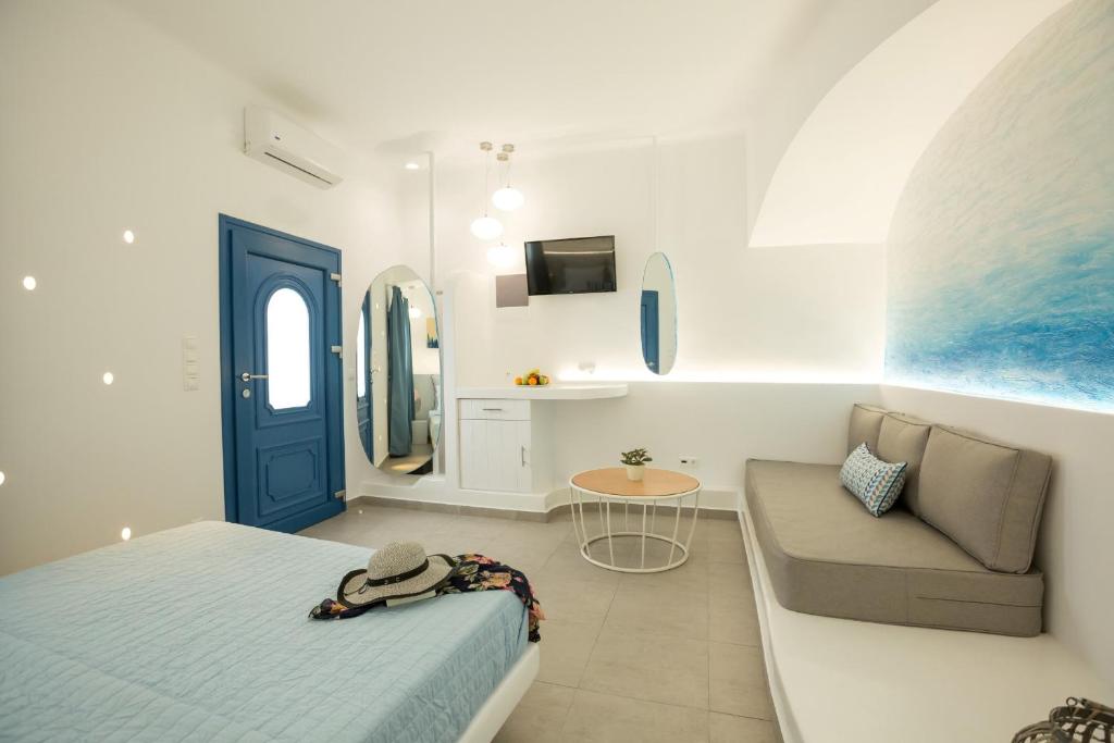 a bedroom with a bed and a couch and a table at Amera Suites in Fira