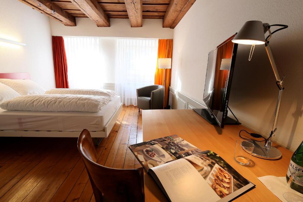 a bedroom with a bed and a desk with a book at Hotel Roter Ochsen in Solothurn