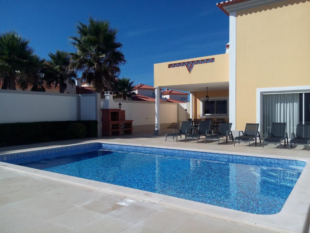 a swimming pool in front of a villa at Praia Del Rey PrivatePool Beach Golf in Amoreira
