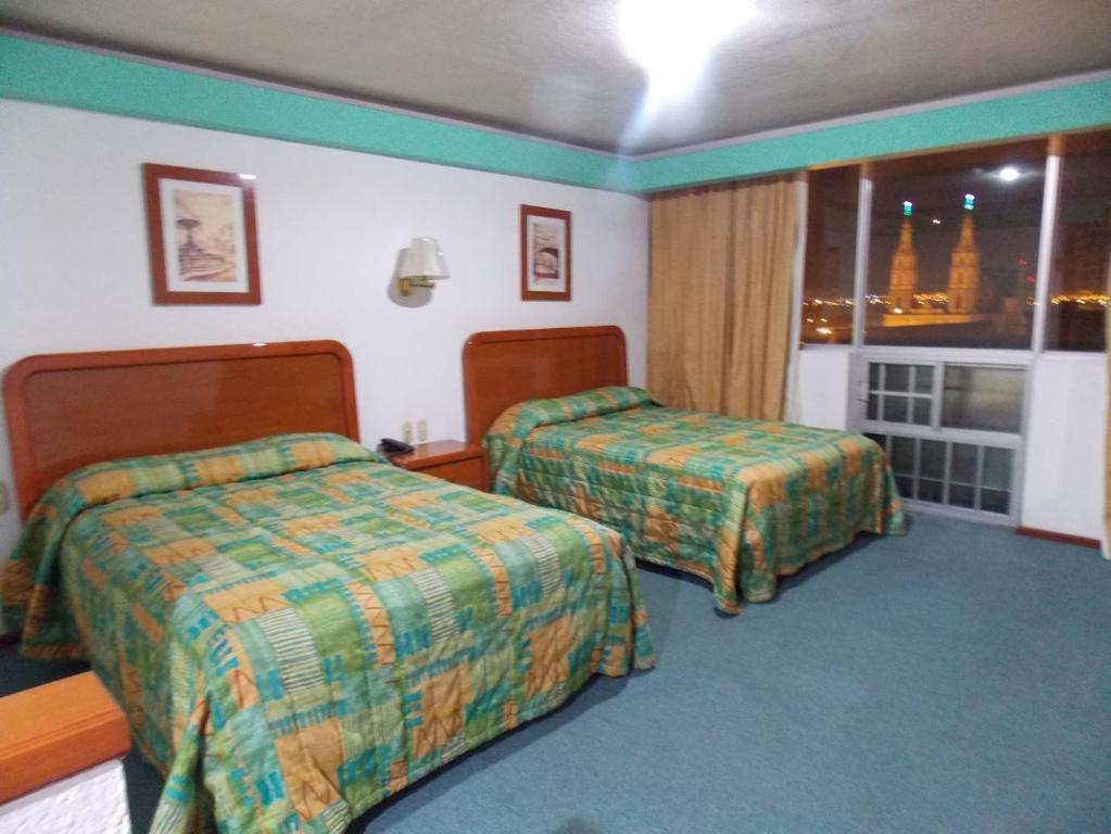 Postel nebo postele na pokoji v ubytování Hotel Real Rex