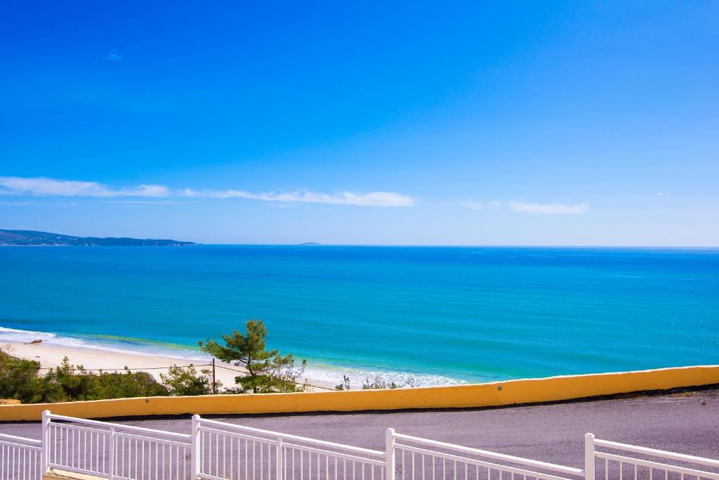 a view of a beach with a white fence at Hotel Diamond in Limenaria