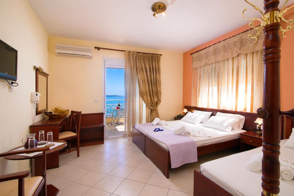 a hotel room with a bed and a view of the ocean at Hotel Diamond in Limenaria