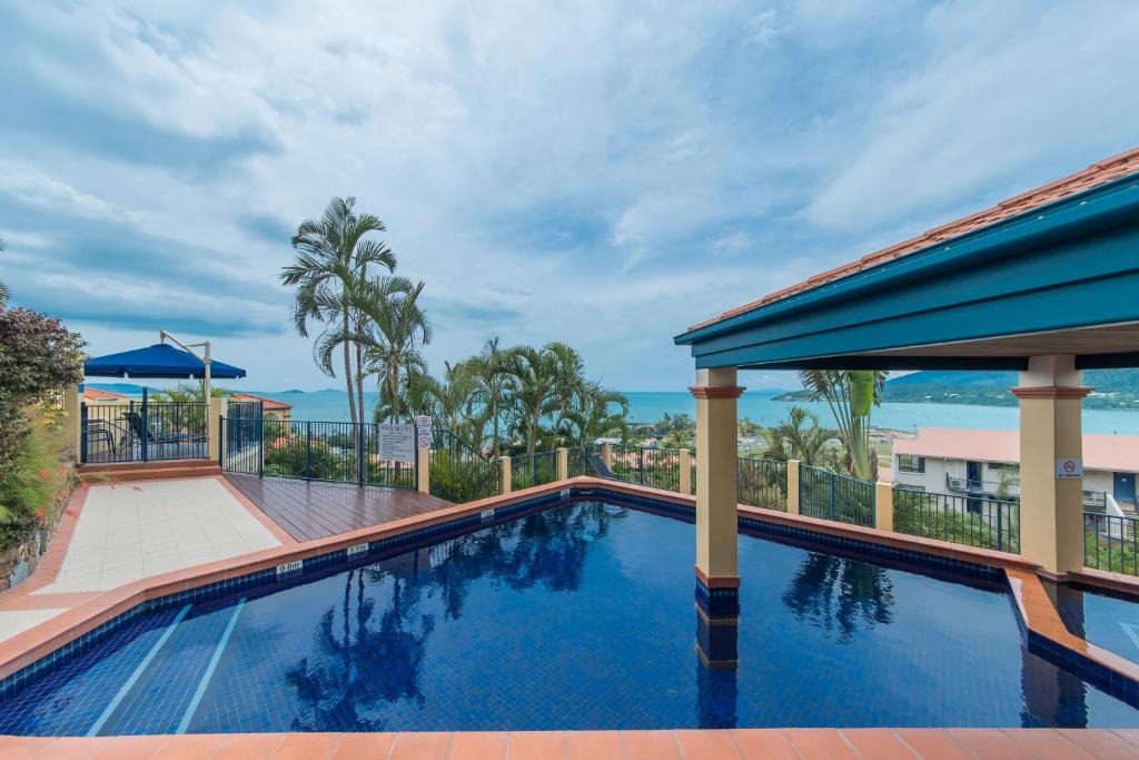 a swimming pool with a view of the ocean at Magnificence At Airlie in Airlie Beach