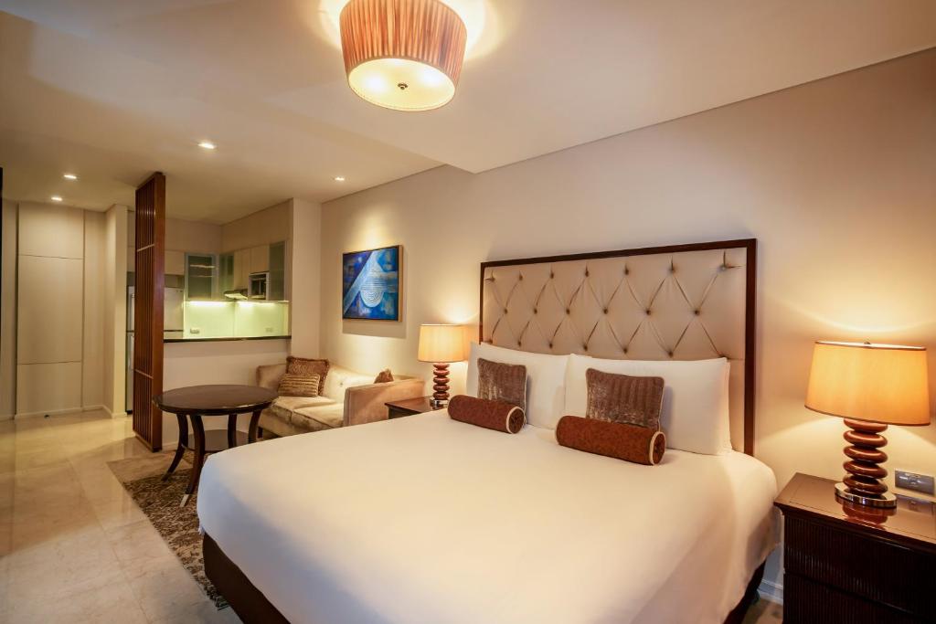 a bedroom with a large bed and a living room at Joy Nostalg Hotel and Suites Manila Managed by The Ascott Limited in Manila