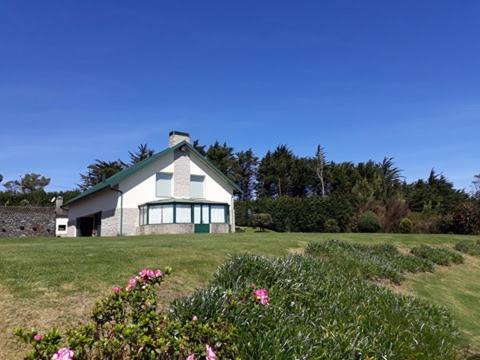 a large white house in a field with flowers at Luxury VILLA CAMÉLIA. Mountains, golf, horses, levada walks. in Santo da Serra