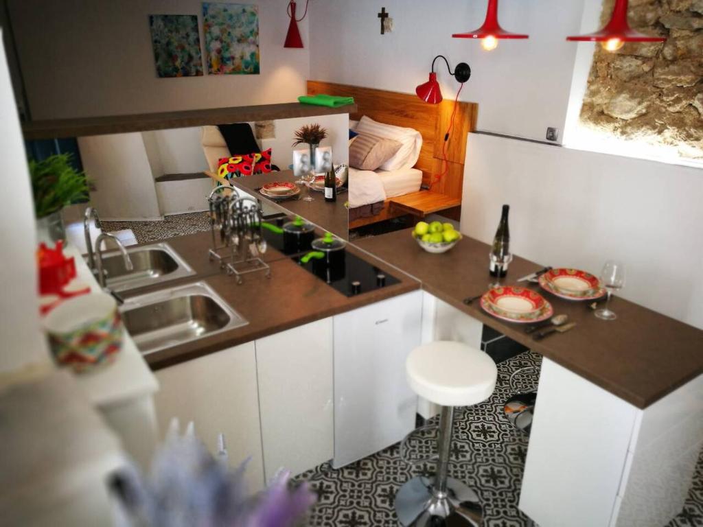 a small kitchen with a counter top and a living room at Cres Studio Till Apartment in Cres