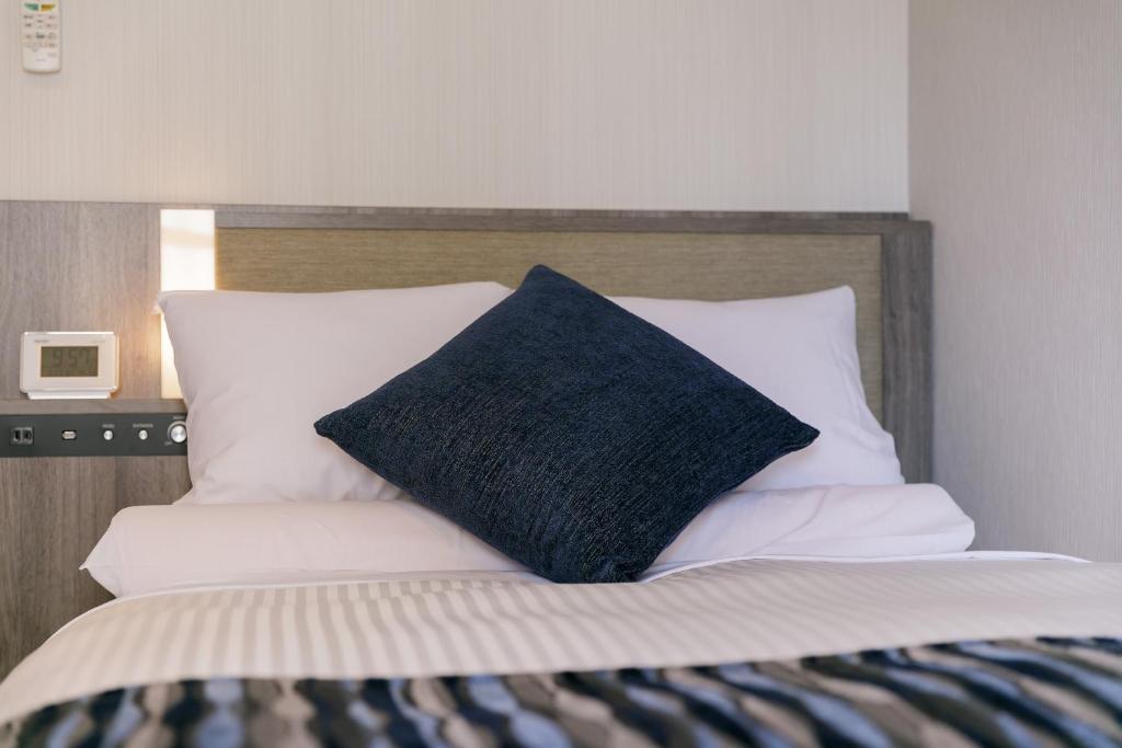 Postel nebo postele na pokoji v ubytování Hotel Mystays Kagoshima Tenmonkan Annex
