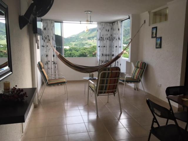 Habitación con mesa, sillas y hamaca. en Apartamento En el Rodadero, en Santa Marta