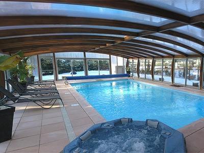 a large swimming pool in a large building at Logis Hotel-Restaurant Spa Le Lac in Embrun