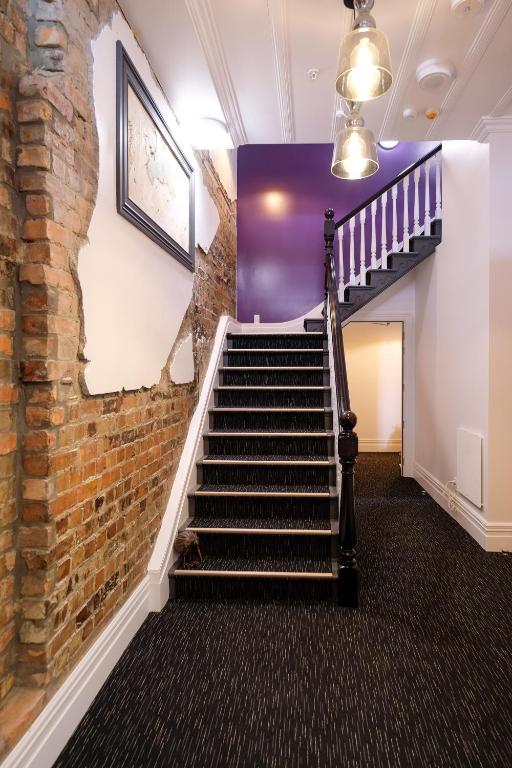 a staircase in a room with a brick wall at Haka House Auckland K'Road in Auckland